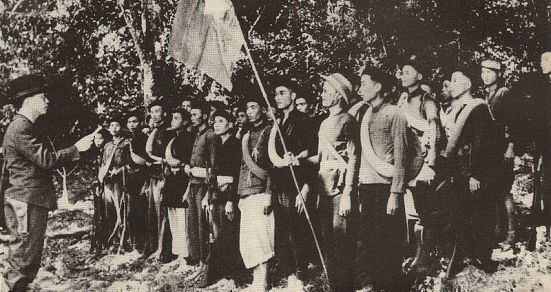 Buổi lễ thành lập đội Việt Nam Tuyên truyền Giải phóng Quân; Võ Nguyên Giáp (bìa trái), Hoàng Văn Thái cầm cờ