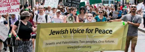 Phản đối chiến tranh tại Hoa Kỳ bởi người Do Thái Mỹ, Hai người mang băng rôn đeo cờ Palestine (trên cổ tay và trên ngực) Biểu ngữ đề “Tiếng nói Do Thái cho Hoà Bình: Người Israel và người Palestine. Hai dân tộc. Một tương lai” 