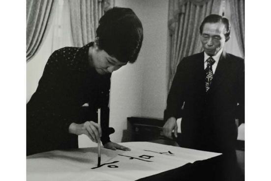 Bà Park Geun Hye dùng bút lông viết thư pháp tiếng Triều Tiên, bên phải là cha của bà: Tổng thống Park Chung Hee. Ảnh chụp tại Seoul vào 31 tháng Tám năm 1977, lúc này bà Park đang phải nhận cương vị Đệ nhất Phu nhân vì mẹ bà đã bị bắn chết trong một vụ ám sát hụt ông Park năm 1974. Ông Park thuộc thế hệ được đào tạo tại Nhật, còn bà Park thuộc thế hệ học xong Cử nhân hoàn toàn tại Hàn Quốc.