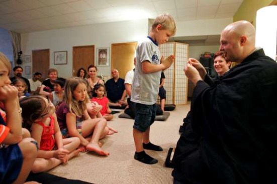 ADVANCE FOR USE SUNDAY, JULY 17, 2011 AND THEREAFTER - In this Sunday, June 19, 2011 photo, Rev. Jay Rinsen hands Mala beads to Kasen Knapp, 6, at the Toledo Zen Center in Holland, Ohio. The center has created a Sunday school and other programs to be especially welcoming to families. Many U.S. Buddhists say that meditation centers arent especially welcoming of children, and some worry it will cost them the next generation of adherents. (AP Photo/JD Pooley)