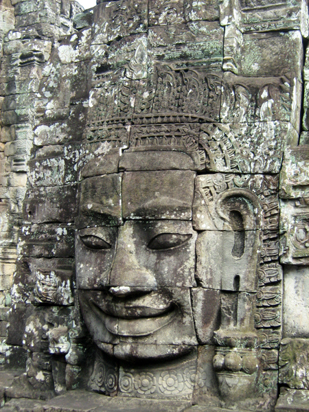 Một trong bốn khuôn mặt nhìn bốn hướng với nụ cười thần bí tạc trên tháp trung tâm. Đây là tượng được nhiều du khách đứng cạnh để chụp hình nhất vì người ta tin sẽ được mang lại nhiều may mắn. (Hình : Colnav Nguyen)